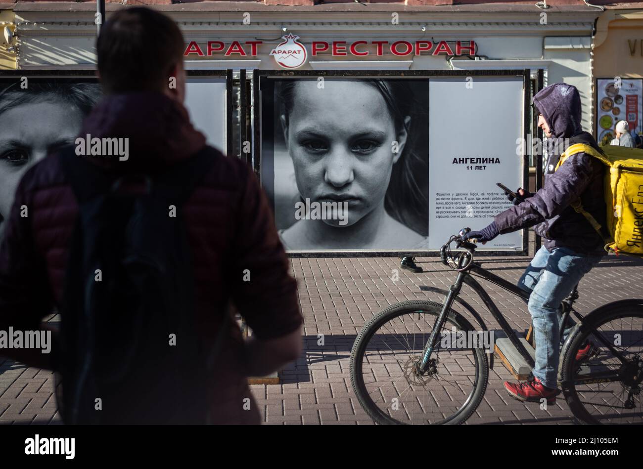(220321) -- MOSCOU, le 21 mars 2022 (Xinhua) -- les gens regardent les œuvres de l'exposition de photos "regard dans les yeux de Donbass" sur la rue Arbat à Moscou, en Russie, le 20 mars 2022. (Xinhua/Bai Xueqi) Banque D'Images