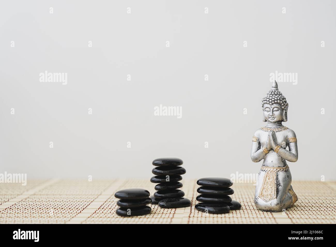 Figurine Bouddha avec pierres noires Banque D'Images