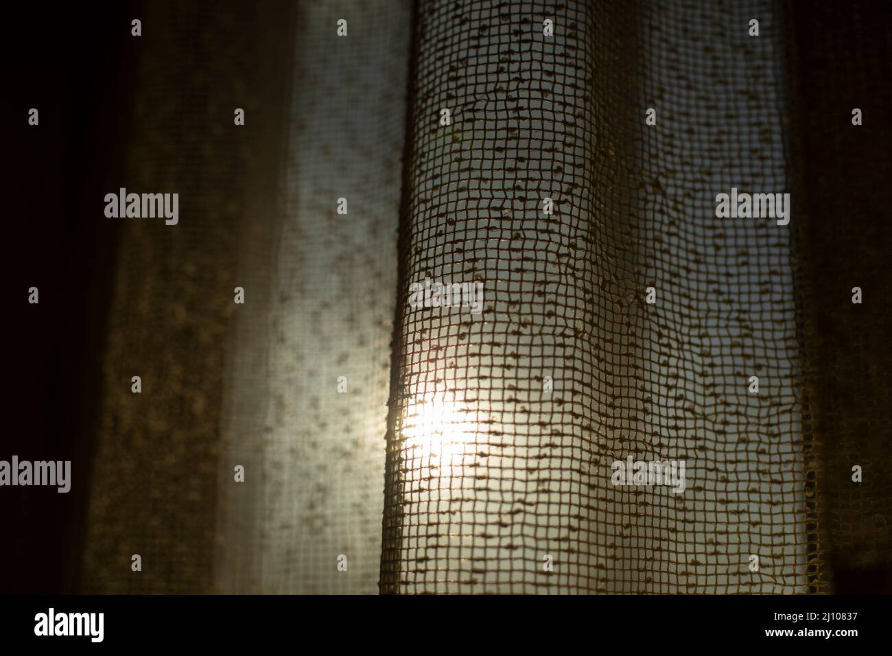 Le soleil brille à travers les rideaux. Rideaux sur la fenêtre. Lumière du matin. Atmosphère fraîche. Banque D'Images