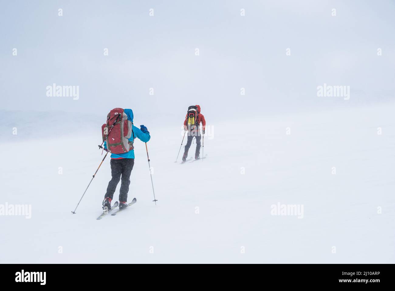 Deux skieurs dans des conditions difficiles ski de randonnée dans les montagnes de Norvège Banque D'Images