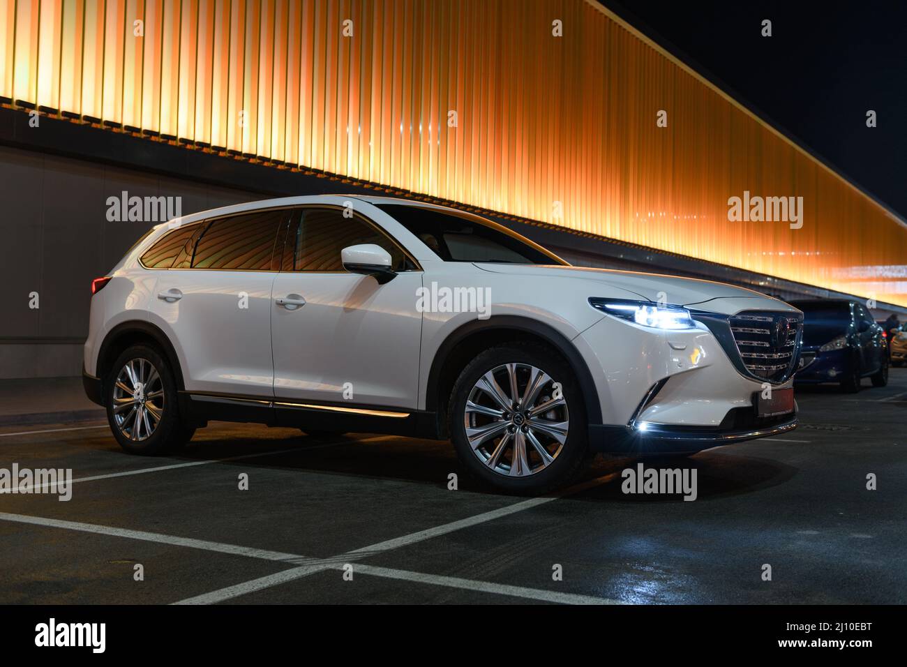 Kiev, Ukraine - 4 décembre 2021: Moderne SUV de luxe Mazda CX-9 au parking près du mur illuminé coloré Banque D'Images