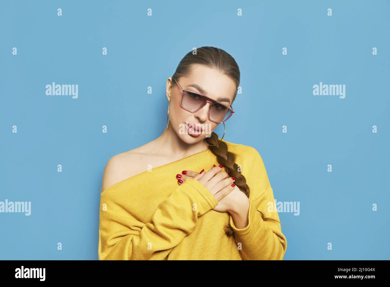 Gros plan une jeune femme pacifique et pieuse tenant les mains sur la poitrine à cœur, en faisant du voeu, en priant, en montrant le signe de gratitude. Love Ukraine concept. Banque D'Images