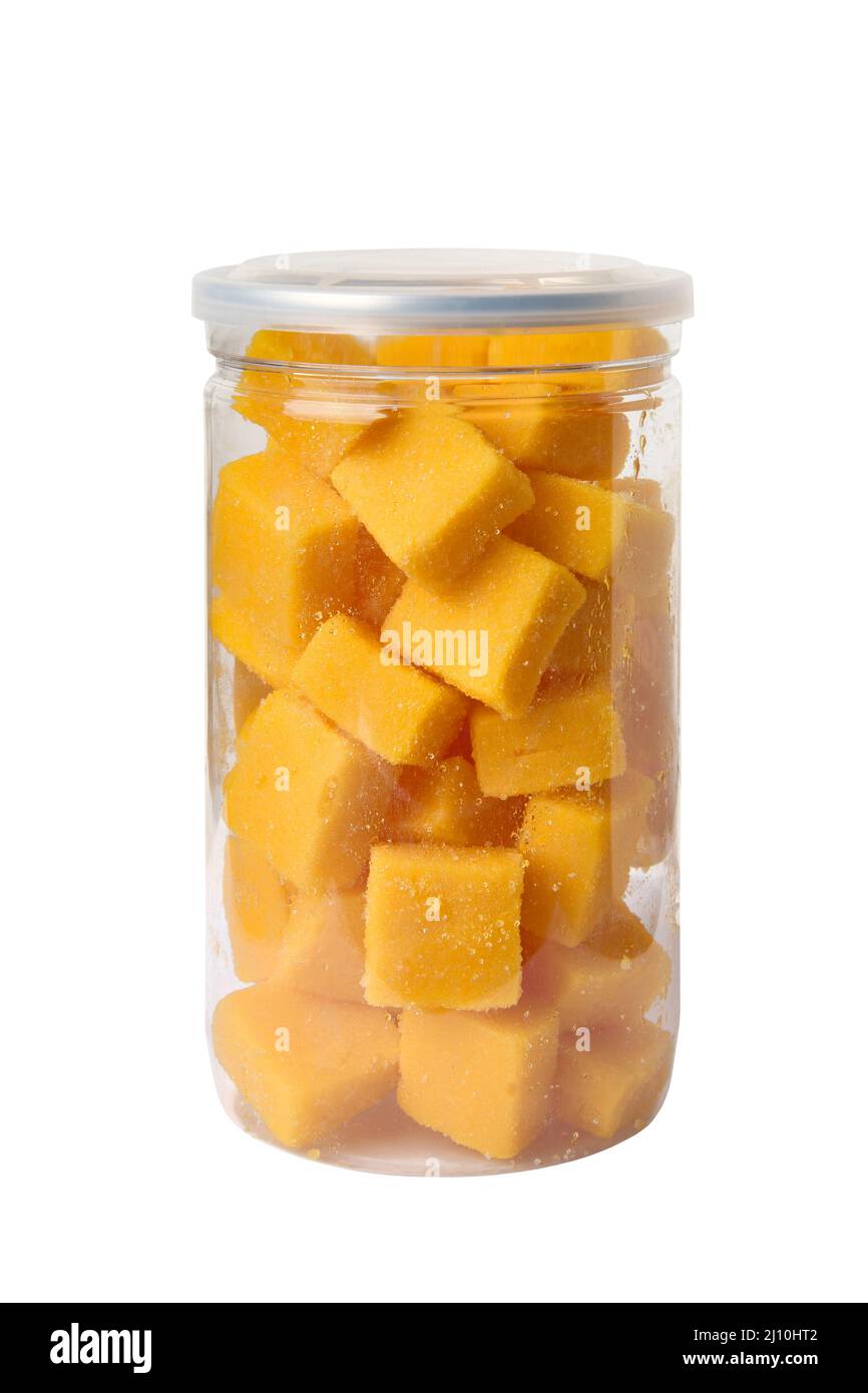 Cubes de mangue en sucre emballés dans un pot en plastique isolé sur fond blanc Banque D'Images