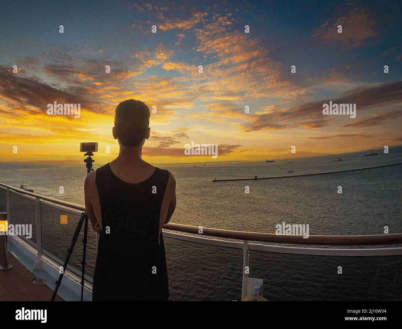 Portrait d'un jeune touriste noir sur le pont d'un bateau de croisière devant un ciel de coucher de soleil. Touriste africain sur la plage. Banque D'Images
