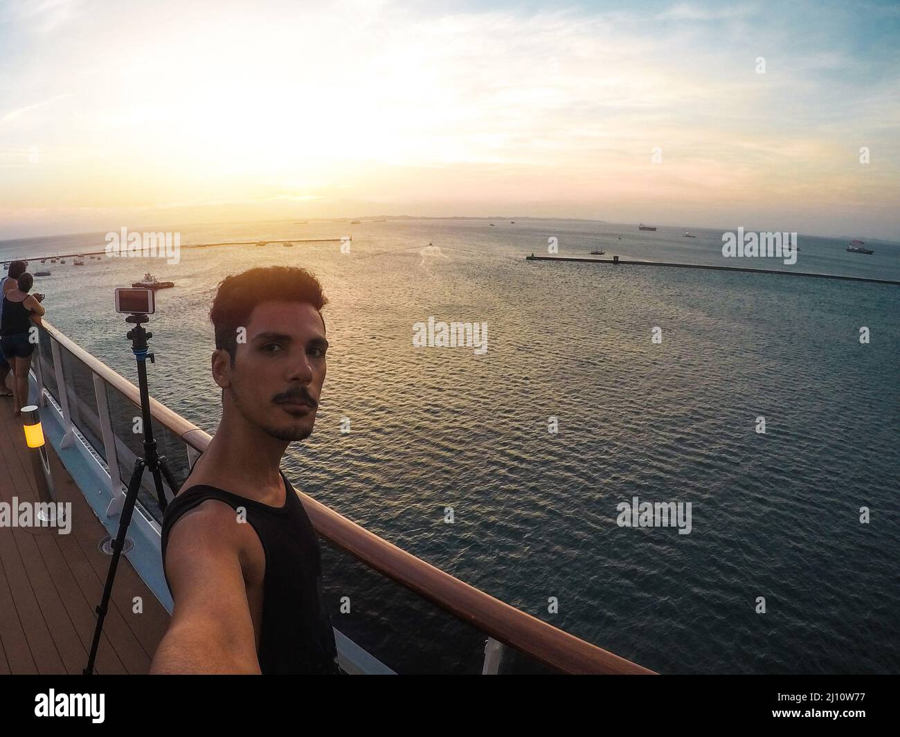 Portrait d'un jeune touriste noir sur le pont d'un bateau de croisière devant un ciel de coucher de soleil. Touriste africain sur la plage. Banque D'Images
