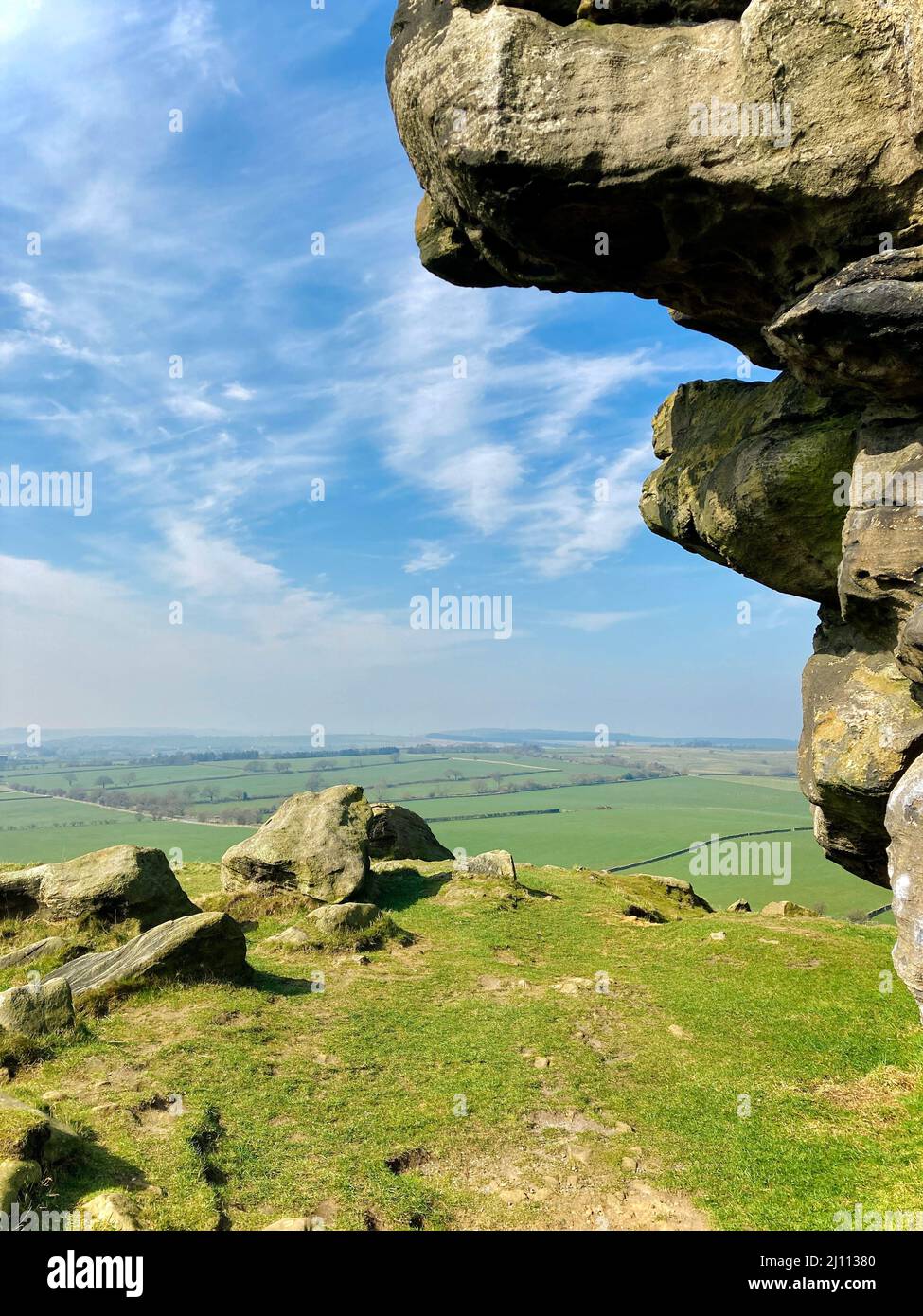 Paysage pittoresque vue sur le ciel bleu sur les champs verts de l'Almscliffe Crag a Millstone Grit outcrop dans la campagne du Yorkshire du Nord. Banque D'Images