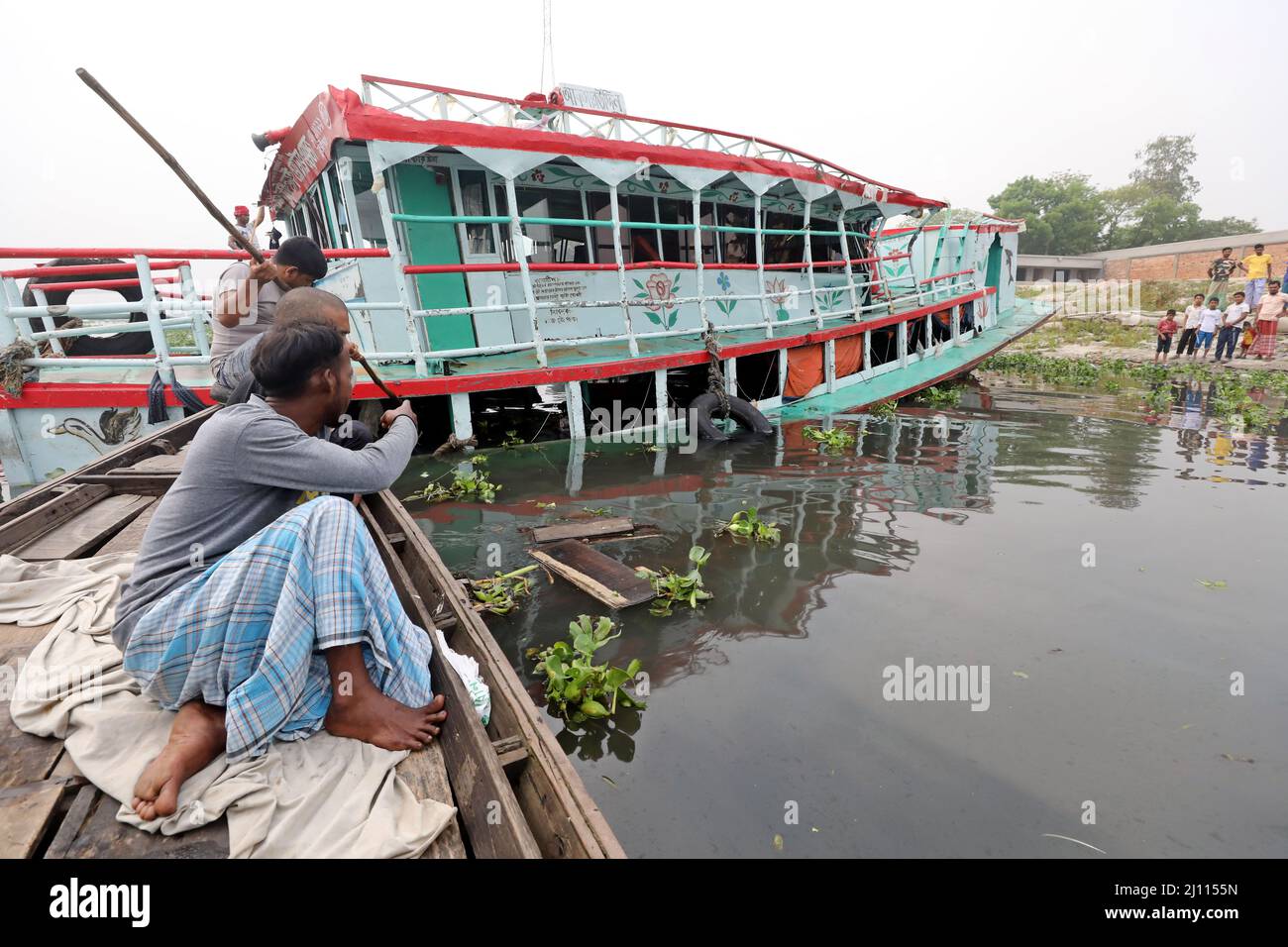 DHAKA,BANGLADESH,MARS: Les gens sur un bateau à bord du ferry secouru à la suite d'un accident dans la rivière Shitalakshya à Narayanganj le 21 mars 2022. - À Banque D'Images