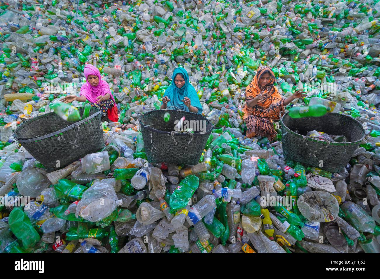 Les travailleurs trient les bouteilles en plastique usagées dans une usine de recyclage située à Noakhali, au Bangladesh. Ces bouteilles sont principalement collectées par des motards et des enfants de la rue, qui seront plus tard vendus aux usines locales. Les usines de tous les jours comme celles recyclent des milliers de bouteilles pour fabriquer différents types de produits en plastique. Avec le plastique qui ne se défait jamais, le recyclage du plastique au Bangladesh est une grande industrie de nos jours. Bangladesh. Banque D'Images