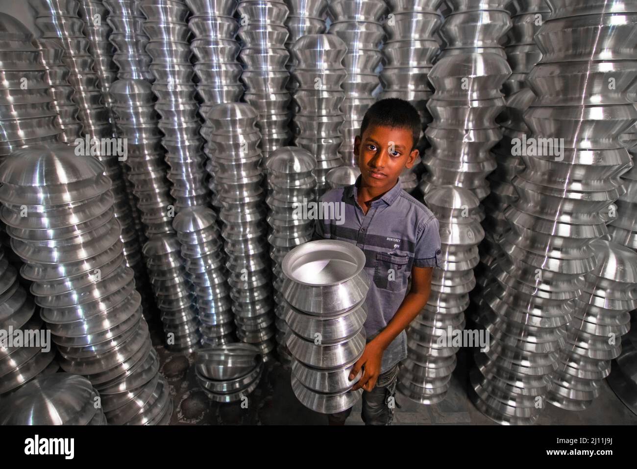 Un travail d'enfant travaille dans une usine de fabrication de pots d'aluminium à Narayanganj, au Bangladesh. Le travail des enfants au Bangladesh est courant, avec 4,8 millions ou 12,6% des enfants âgés de 5 à 14 ans dans la population active. Bangladesh. Banque D'Images