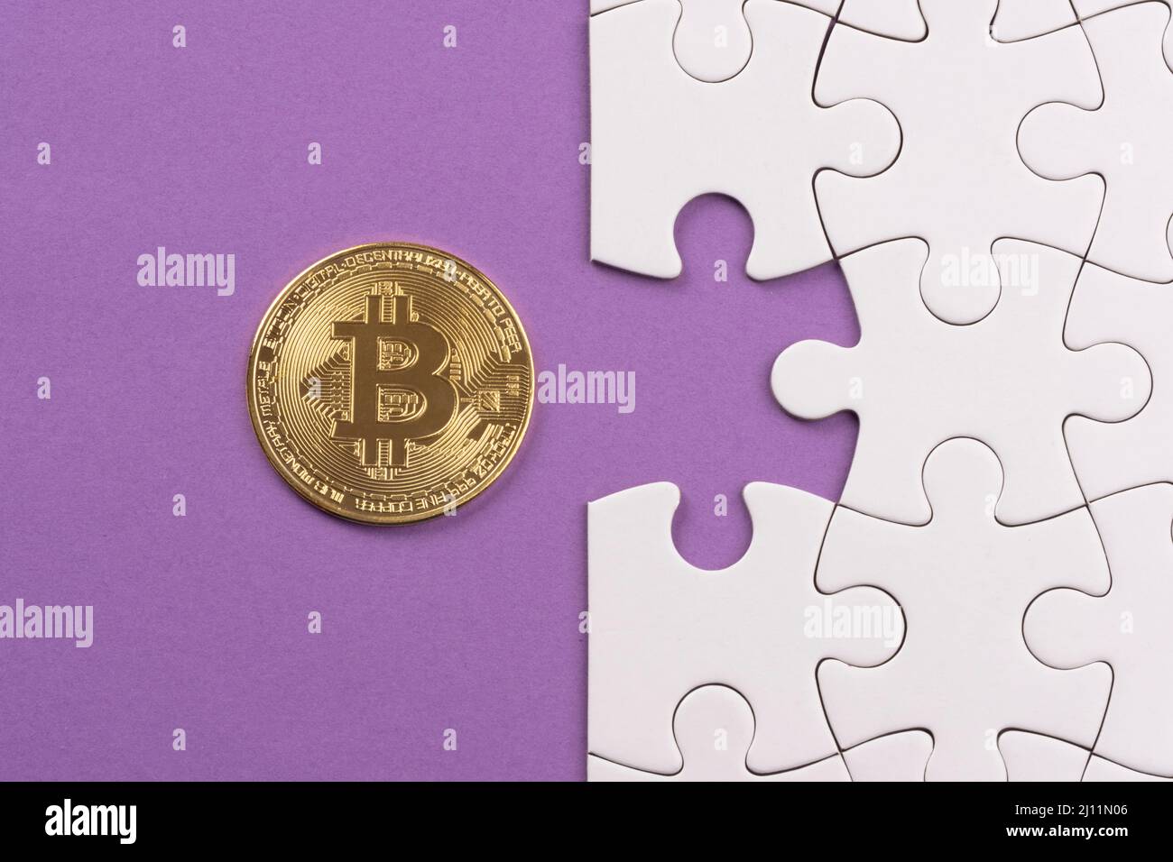 Puzzle Golden Bitcoin pour finir. Jeu de puzzle blanc sur surface mauve. Correspondance, insertion de la dernière pièce manquante. Résolution de problèmes d'entreprise et de travail d'équipe Banque D'Images