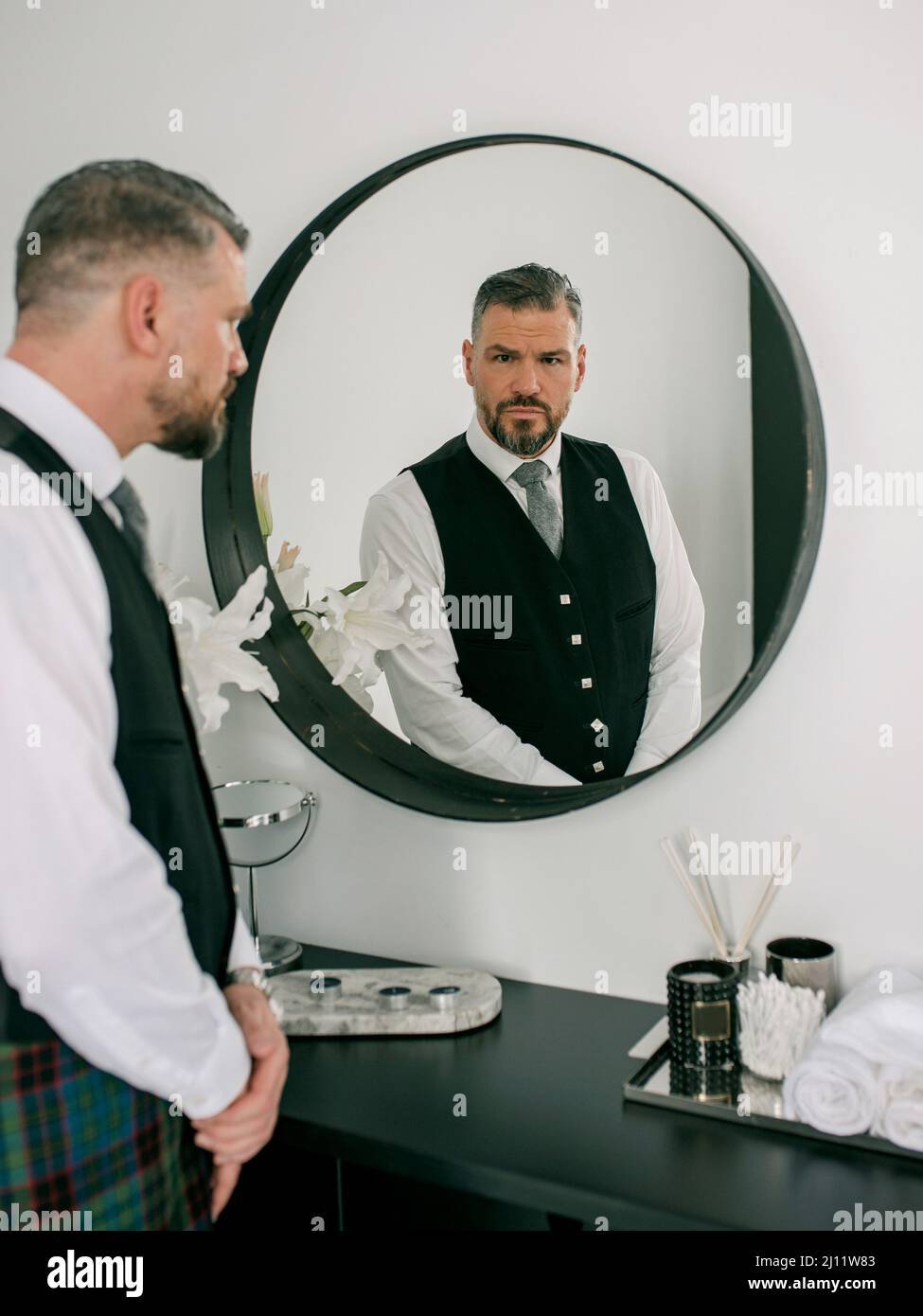 beau mûr courageux élégant homme scotsman en costume par le miroir. Style, mode, style de vie, culture, concept ethnique. Banque D'Images