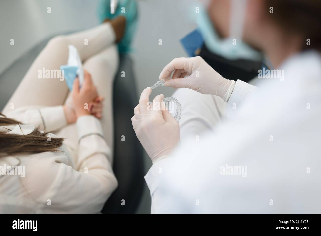 Dentiste professionnel montrant et expliquant à un client comment fonctionne l'invisalign Banque D'Images