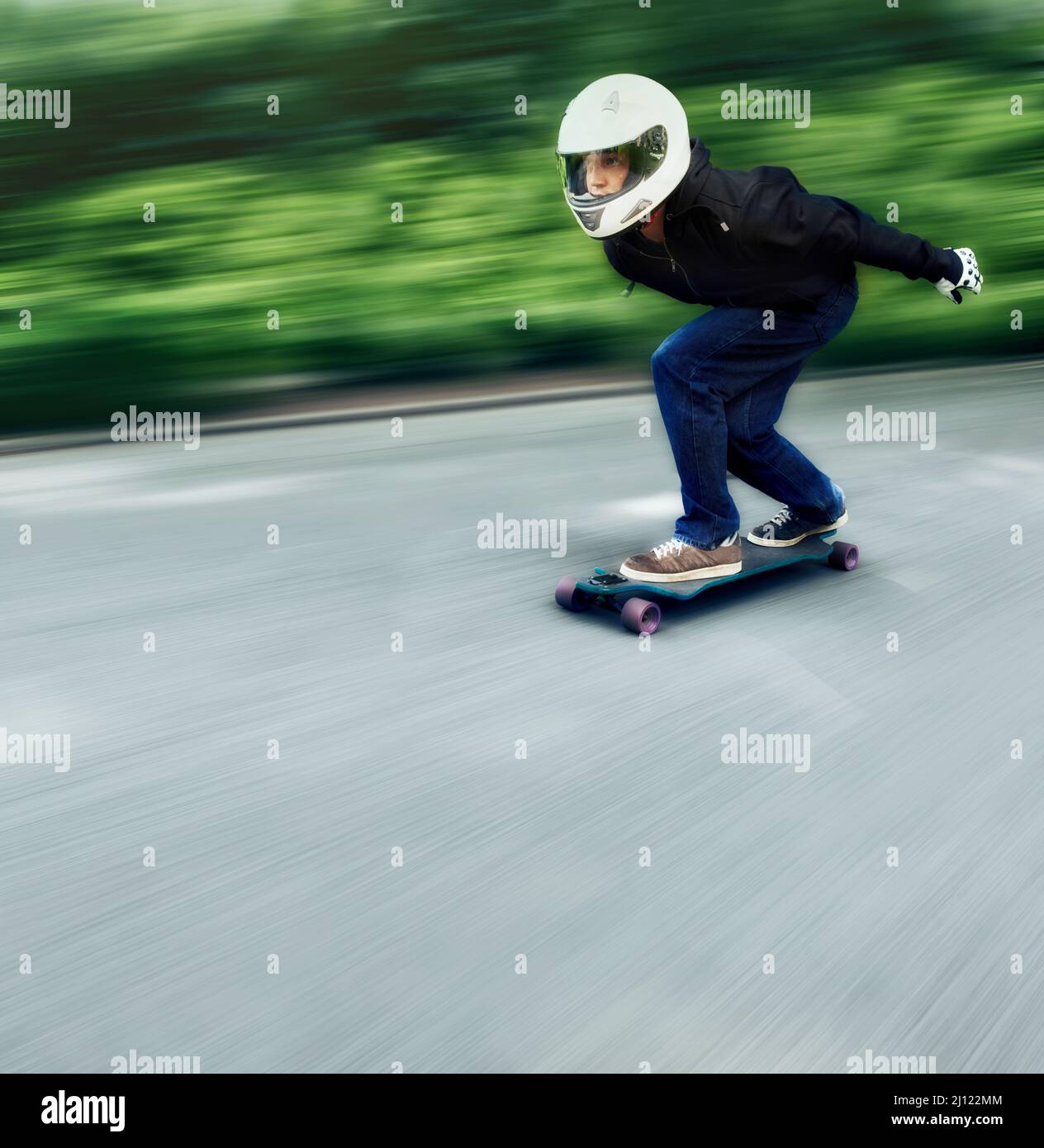 Ravie par la vitesse. Photo d'un homme qui fait du skateboard sur une voie à grande vitesse sur son plateau. Banque D'Images