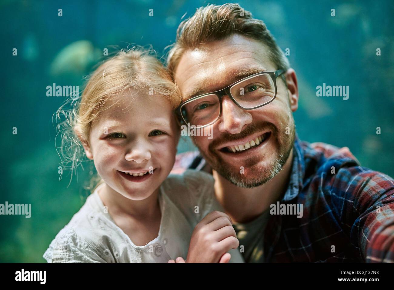 Pour une expérience durable. Portrait d'un père et de sa petite fille emportant un selfie ensemble dans un aquarium. Banque D'Images