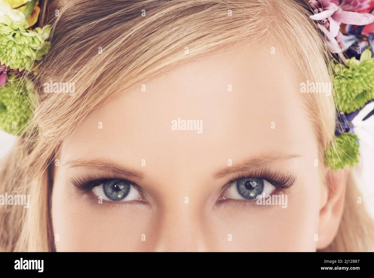 Les yeux d'une déesse printanière. Portrait d'une jeune femme attrayante avec de belles fleurs. Banque D'Images