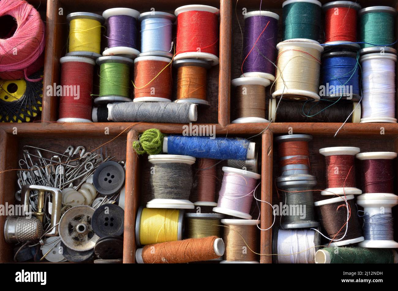 Vue dans un panier de travail avec des bobines de fil de couture dans de nombreuses couleurs. Banque D'Images
