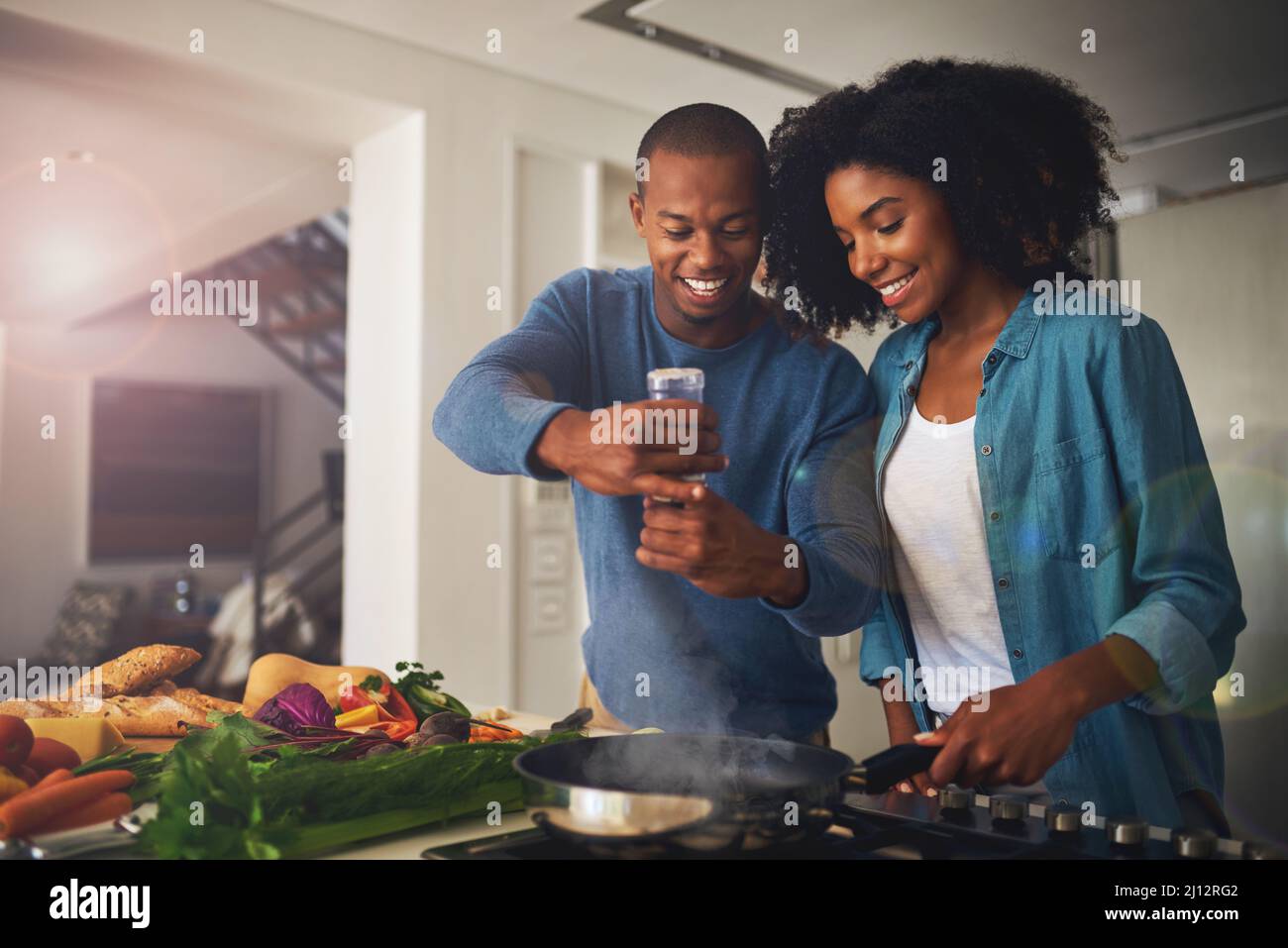 Un peu de poivre va beaucoup. Photo d'un jeune couple joyeux prenant une photo des ingrédients du repas qu'ils sont sur le point de préparer ensemble à la maison. Banque D'Images