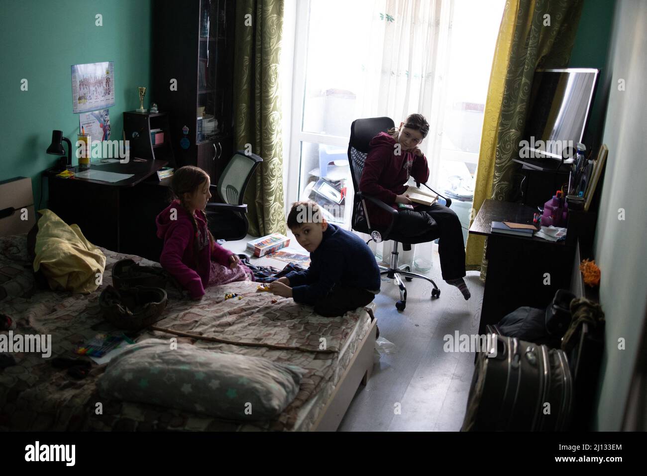 Oksana, la mère de Darina, 13 ans, et Arthur, 7 ans dans leurs appartements au rez-de-chaussée d'un bâtiment où 20 personnes vivent sans électricité, eau ou gaz. Les familles sont des réfugiés de la région de Donbass, ils sont arrivés il y a 2 ans à Irpin pour commencer une nouvelle vie, ils ne veulent pas quitter leur maison à nouveau, même s'il y a des bombardements tout autour d'eux. Central Irpin, comme la ville est en cours de pilonnage pendant l'invasion russe de l'Ukraine, le 11 mars 2022. Photo de Raphael Lafargue/ABACAPRESS.COM Banque D'Images