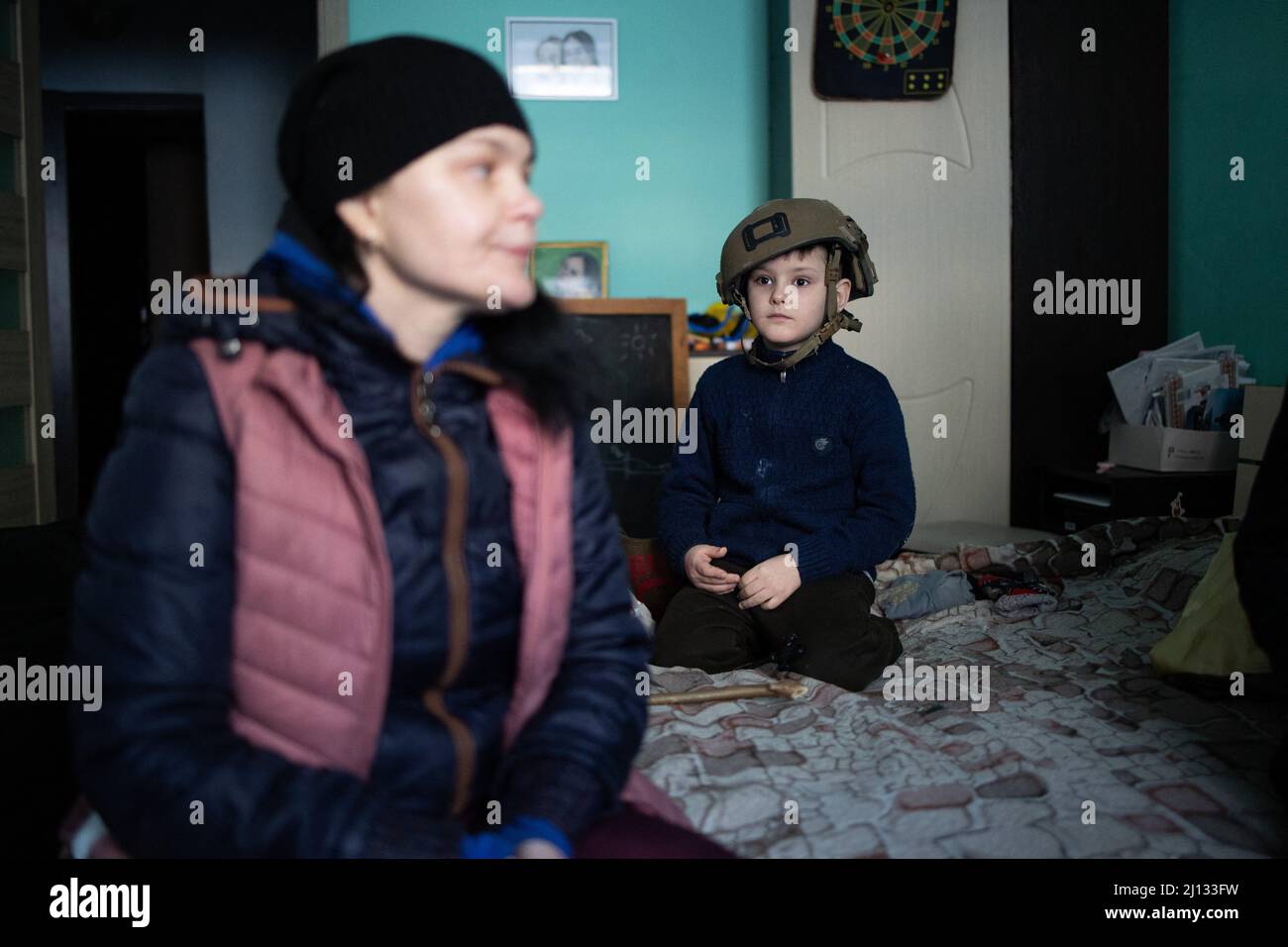 Oksana, la mère de Darina, 13 ans, et Arthur, 7 ans dans leurs appartements au rez-de-chaussée d'un bâtiment où 20 personnes vivent sans électricité, eau ou gaz. Les familles sont des réfugiés de la région de Donbass, ils sont arrivés il y a 2 ans à Irpin pour commencer une nouvelle vie, ils ne veulent pas quitter leur maison à nouveau, même s'il y a des bombardements tout autour d'eux. Central Irpin, comme la ville est en cours de pilonnage pendant l'invasion russe de l'Ukraine, le 11 mars 2022. Photo de Raphael Lafargue/ABACAPRESS.COM Banque D'Images