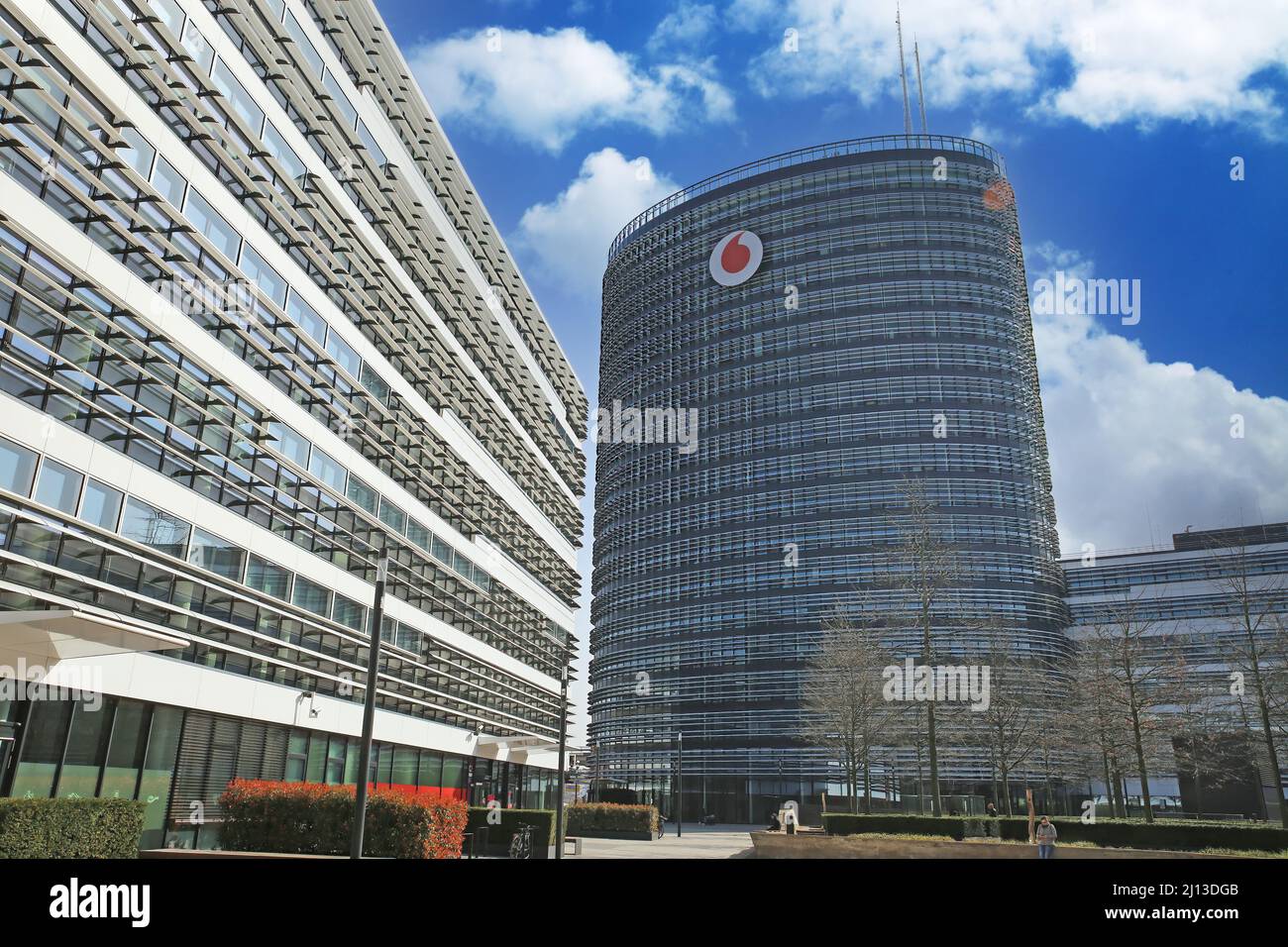 Düsseldorf (campus de Vodafone) - Mars 9. 2022: Vue sur la place sur un bâtiment futuriste avec tour contre ciel bleu avec des nuages blancs moelleux Banque D'Images