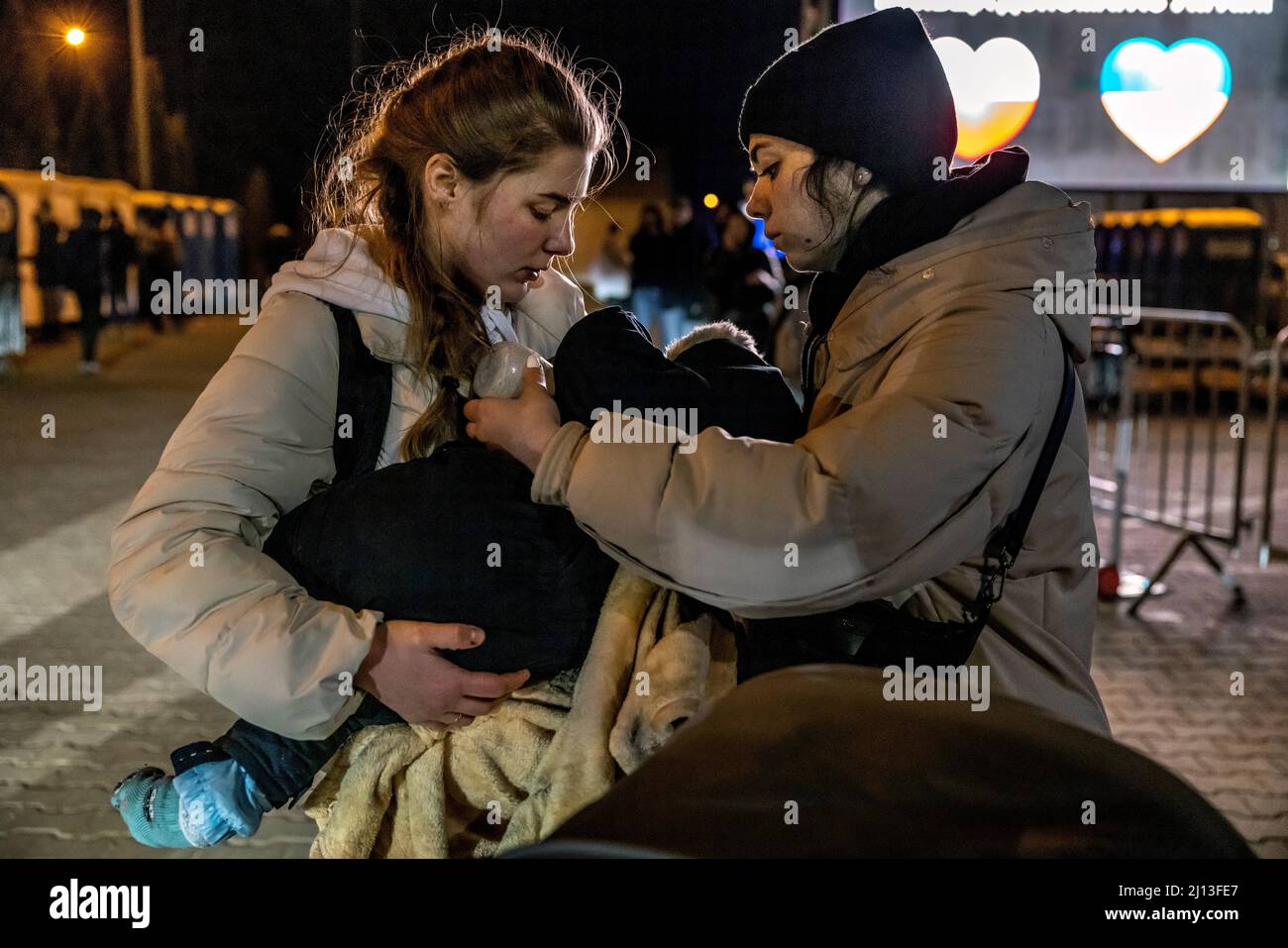 Les réfugiés d'Ukraine ont atteint le point central de collecte des réfugiés dans un centre logistique près de Korczowa, dans la zone frontalière entre la Pologne et l'Ukraine. Ici, ils sont fournis avec de la nourriture et des vêtements et ensuite transportés en bus vers d'autres villes. Banque D'Images