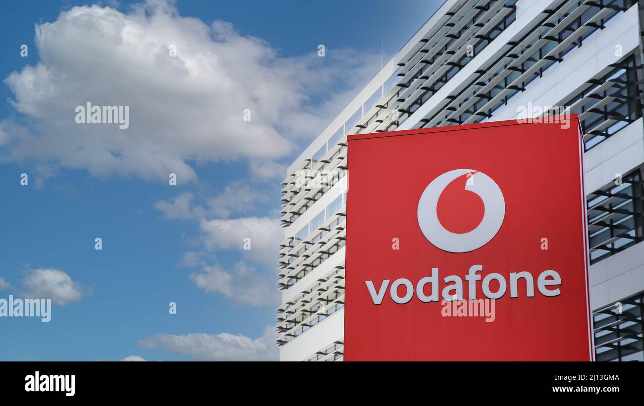 Düsseldorf (campus de Vodafone) - Mars 9. 2022: Vue sur le pilier rouge contre la tour futuriste de bâtiment et le ciel bleu, nuages moelleux Banque D'Images