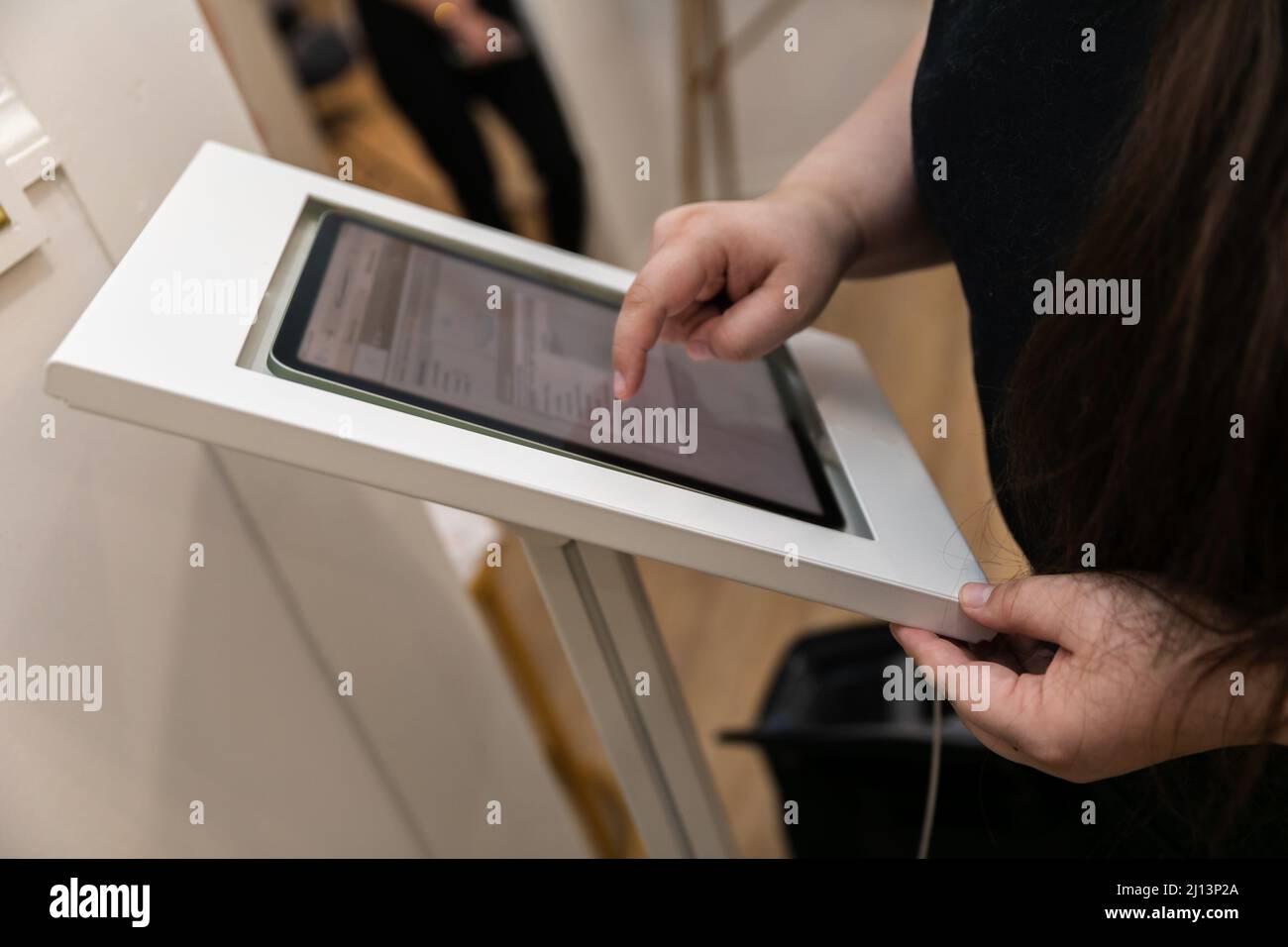 Une femme s'est présente dans un centre de bien-être médical à l'aide d'une tablette électronique pour recueillir ses données personnelles et signer des formulaires et des dispenses médicales Banque D'Images