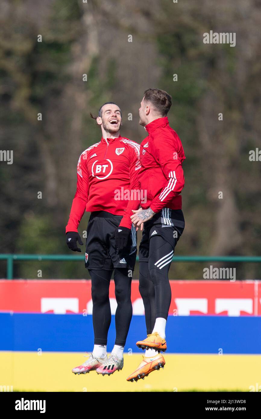 Hensol, pays de Galles, Royaume-Uni. 22nd mars 2022. Gareth Bale bondit avec Joe Rodon devant une palissade montrant les couleurs du drapeau ukrainien pendant l'entraînement de l'équipe nationale de football du pays de Galles à Vale Resort avant le match de demi-finale de la coupe du monde 2022 du côté contre l'Autriche. Crédit : Mark Hawkins/Alay Live News Banque D'Images