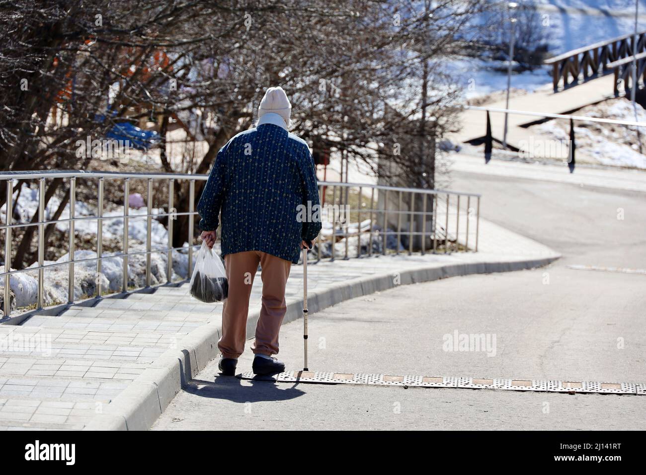 Vieille femme avec promenades en canne dans le parc de printemps. Un mode de vie sain à la vieillesse, la vie à la retraite Banque D'Images