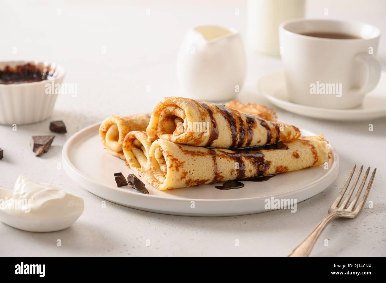Crêpes fines avec crème aigre et garniture au chocolat. Shrovetide. Petit déjeuner traditionnel russe. Gros plan. Banque D'Images