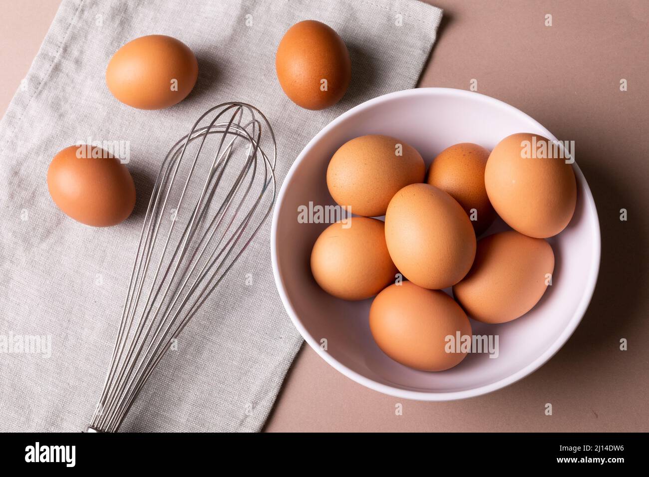 Directement au-dessus de la vue des œufs frais bruns dans un bol, fouetter sur la serviette de table Banque D'Images