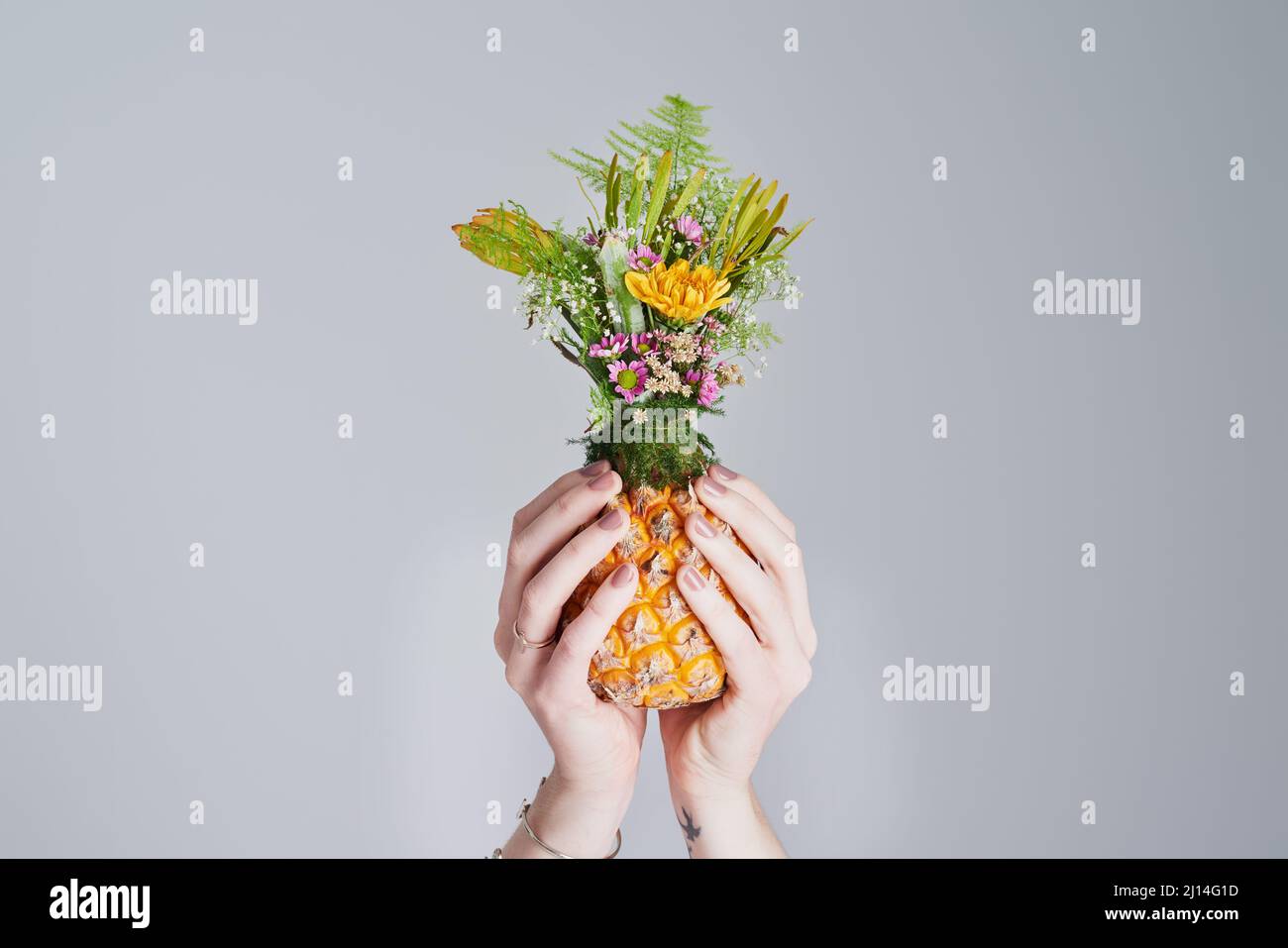 Pour l'amour de toutes les choses belles et naturelles. Photo d'une femme méconnaissable portant un ananas farci de fleurs. Banque D'Images