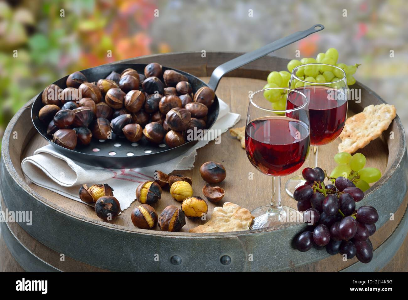 Dégustation de vins dans le Tyrol du Sud avec des châtaignes grillées et le pain de seigle local croquant, appelé Schuettelbrot, servi à l'extérieur sur un tonneau de vin en automne Banque D'Images