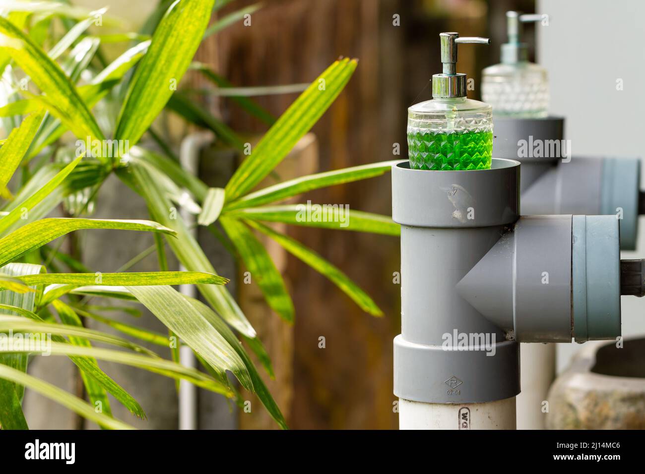 Le savon liquide est actuellement toujours fourni près du robinet d'eau pour se laver les mains, une habitude obligatoire pendant la pandémie Covid-19, concept de santé Banque D'Images