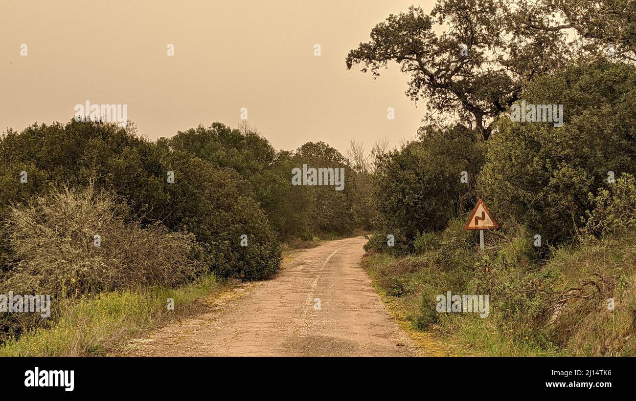 Beau paysage avec route abandonnée et panneau d'avertissement de danger dans la distance à Huelva, Espagne Banque D'Images