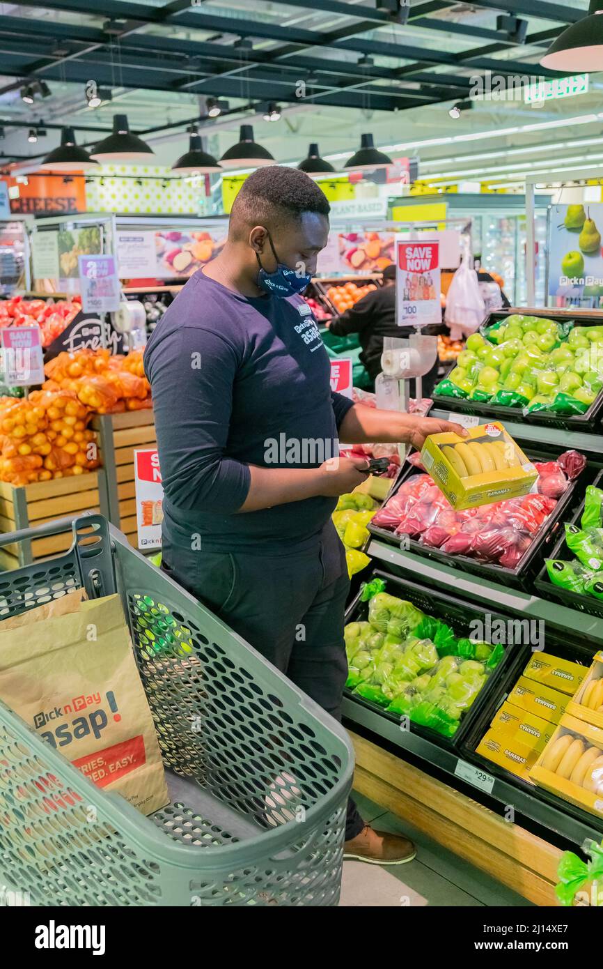 Cape Town, Afrique du Sud - 9 septembre 2021 : un membre du personnel cueille des produits à partir de l'étagère pour un service de livraison express à domicile Banque D'Images