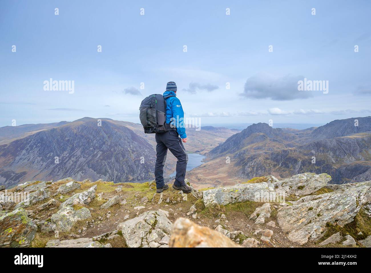 Vue arrière de l'homme isolé dans les montagnes de randonnée par temps humide dans le parc national de Snowdonia, au nord du pays de Galles, au Royaume-Uni, en admirant la vue panoramique sur le paysage. Banque D'Images