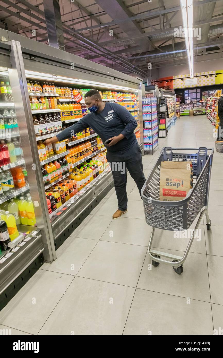 Cape Town, Afrique du Sud - 9 septembre 2021 : un membre du personnel cueille des produits à partir de l'étagère pour un service de livraison express à domicile Banque D'Images