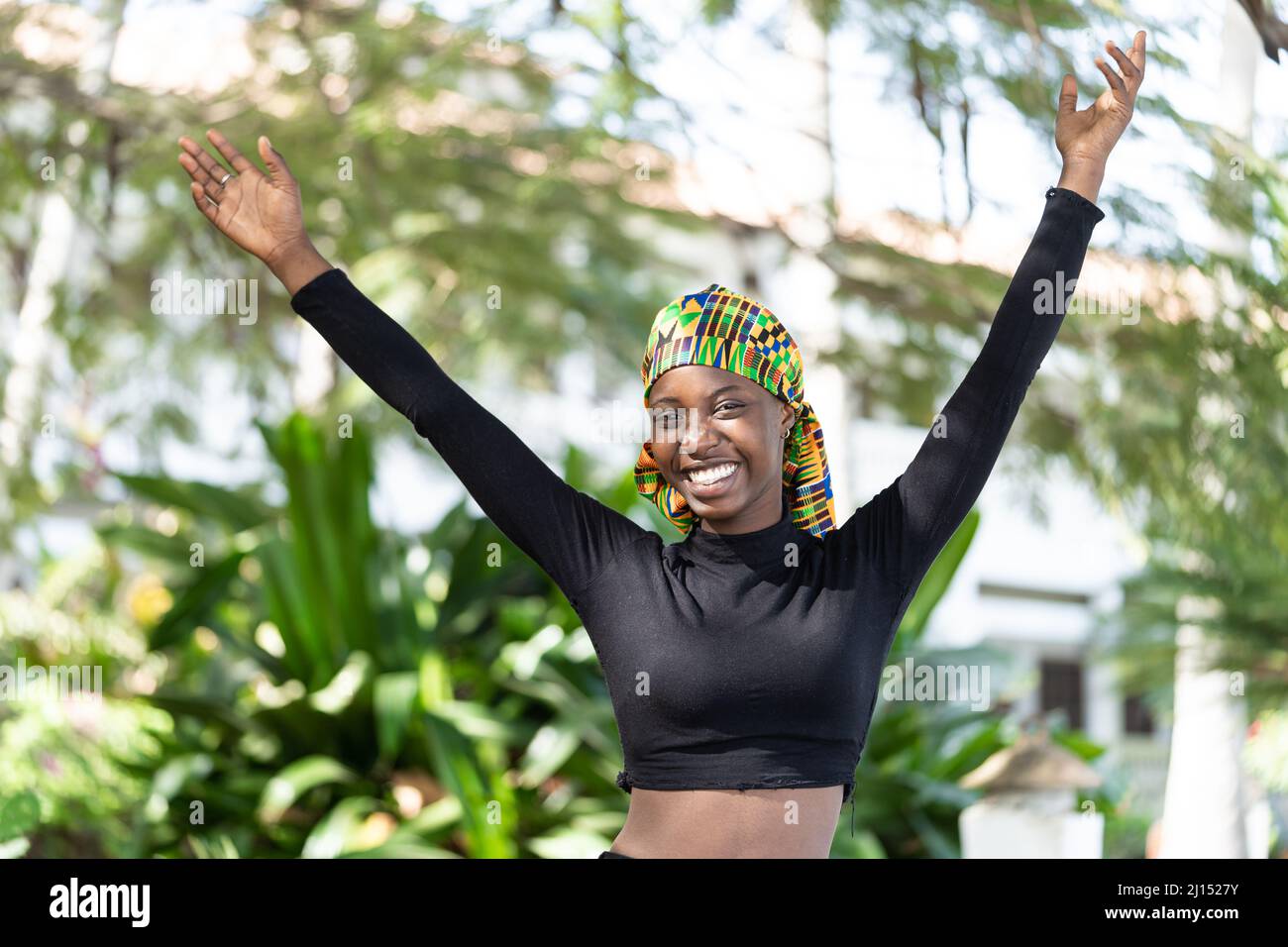 Joyeuse fille africaine magnifique, levant les bras comme un signe de victoire et de succès.Girl Power. Banque D'Images