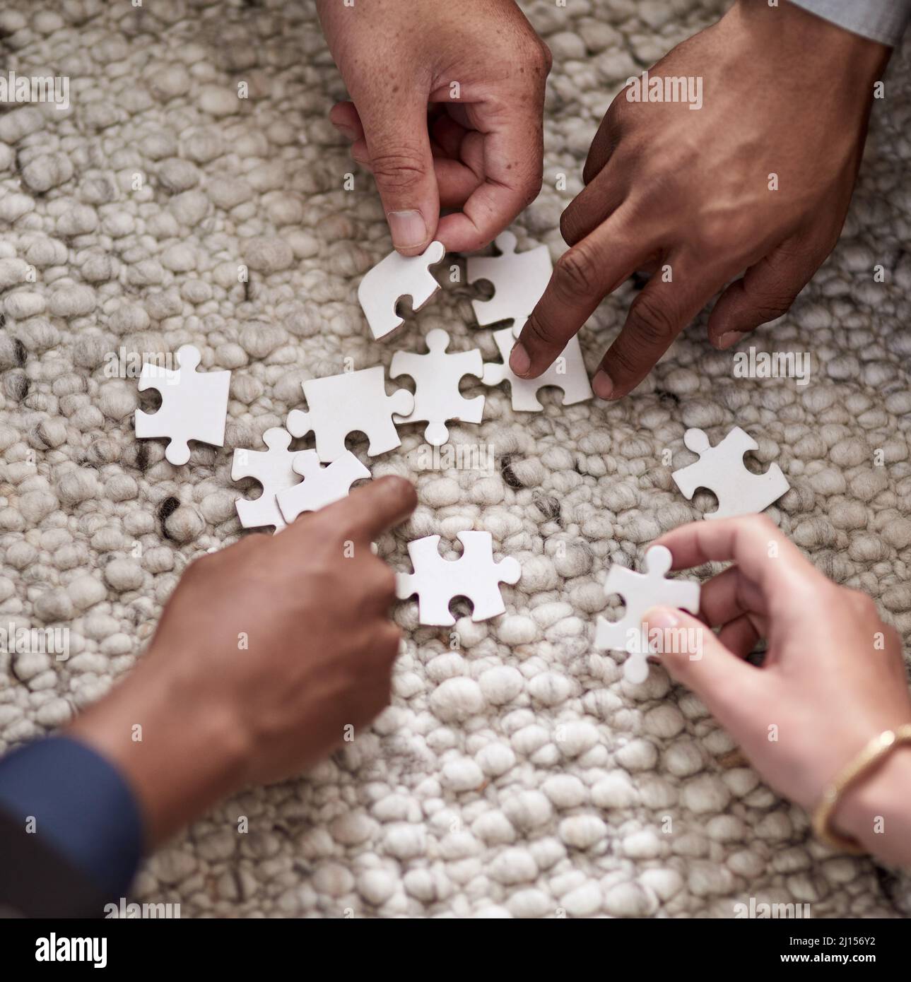 S'unir pour résoudre un problème. Photo rognée d'un groupe de personnes qui s'est rassemblé pour assembler des pièces de puzzle. Banque D'Images