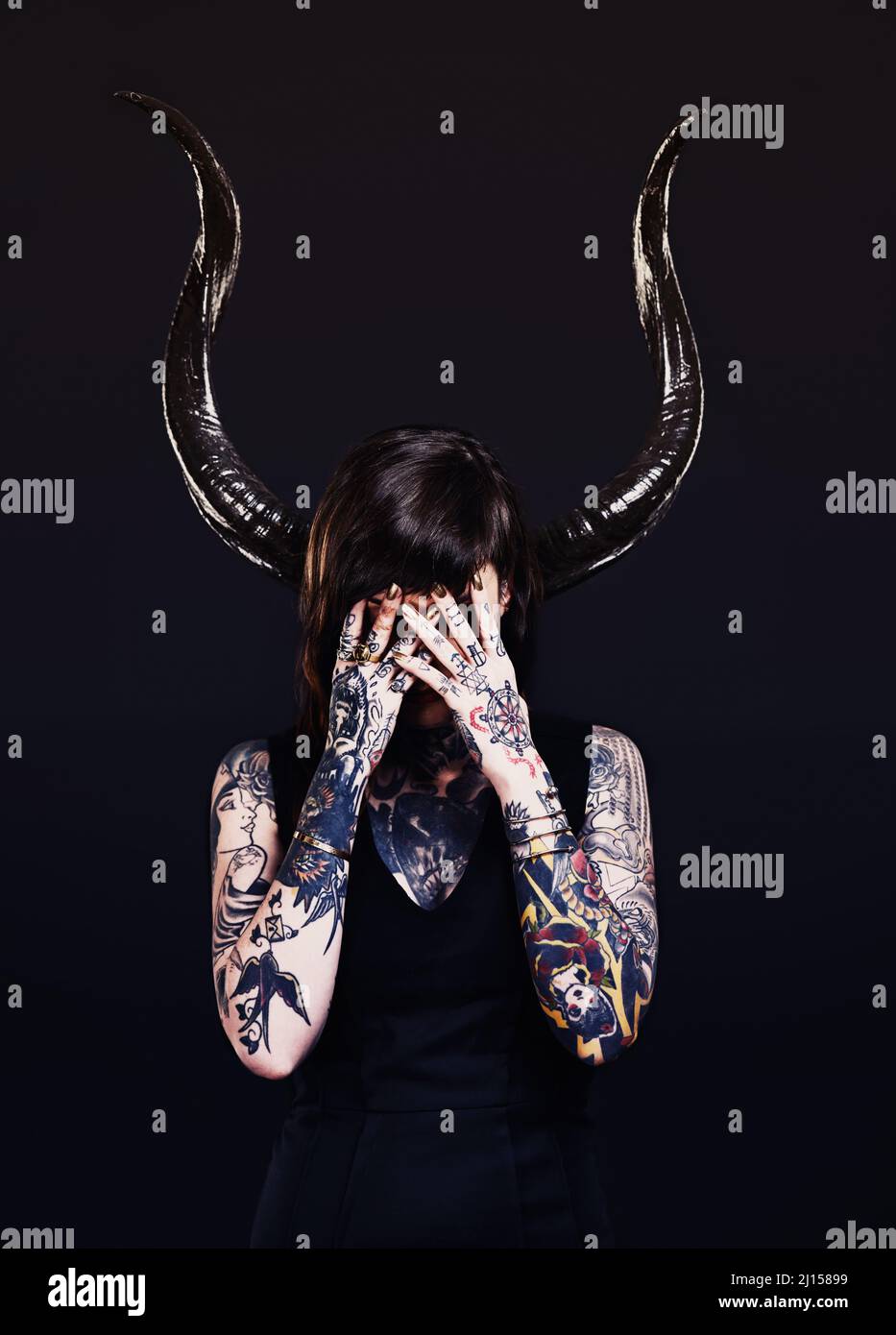 Le côté sombre. Photo studio d'une jeune femme tatouée. Banque D'Images