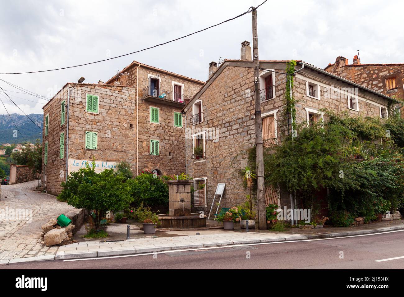 Petreto-Bichisano, France - 18 août 2018 : vue sur la rue de la vieille ville Corse avec maisons en pierre et arbres Banque D'Images