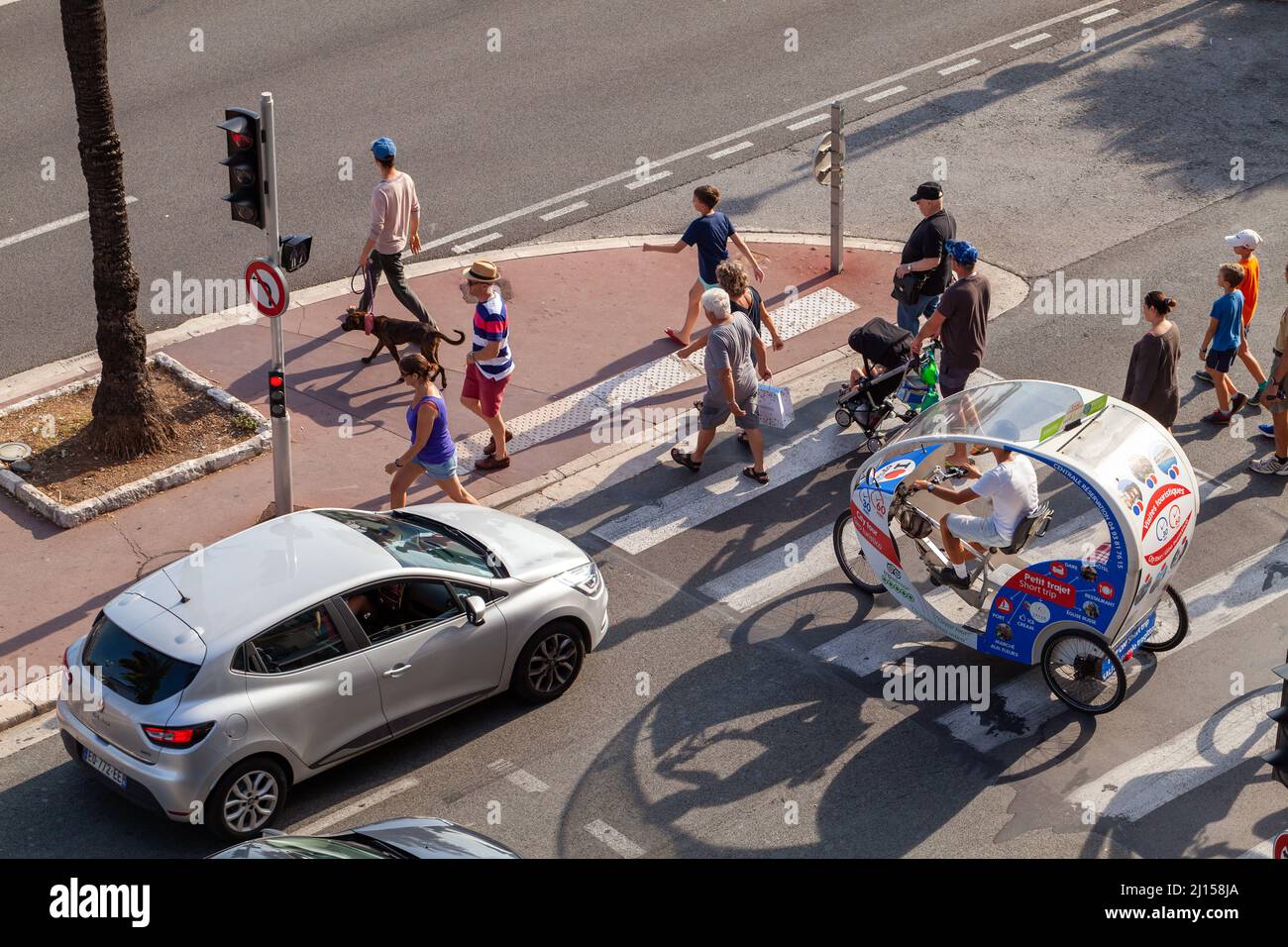 Nice, France - 13 août 2018: Voitures, piétons et touristes trishaw vélo sont sur la route par une journée ensoleillée Banque D'Images