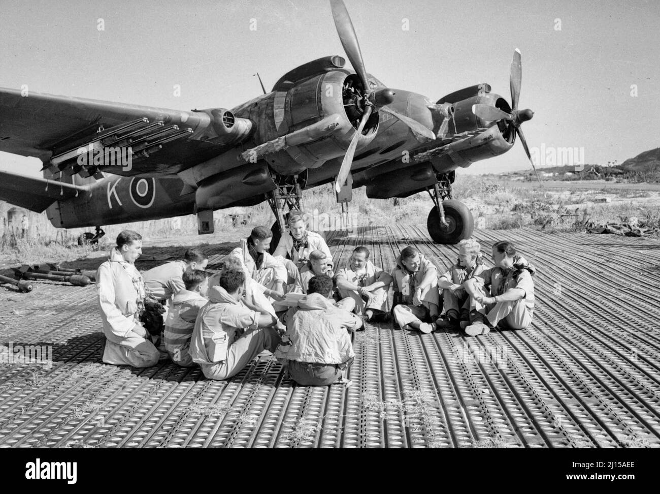 L'équipage du SAAF de l'escadron n° 16 et du RAF de l'escadron n° 227 assis devant un chasseur de Bristol Beaufighter à Biferno, en Italie, avant de partir pour attaquer un bâtiment du quartier général allemand à Dubrovnik, en Yougoslavie, le 14 août 1944. Les équipages de l'escadron no 16 SAAF et de l'escadron no 227 RAF se sont assis dans une dispersion à Biferno, en Italie, avant de se retirer pour attaquer un bâtiment du quartier général allemand à Dubrovnik, en Yougoslavie. Un Bristol Beaufighter Mark X, armé de projectiles de fusée, se tient derrière eux Banque D'Images