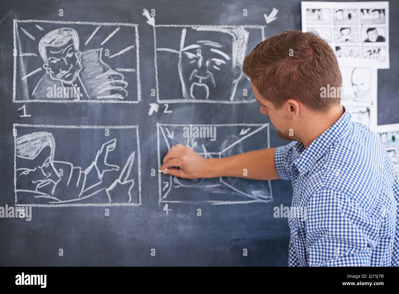 Planification de sa prochaine prise de vue. Un jeune homme qui dessine un storyboard sur son tableau noir de bureau. Banque D'Images