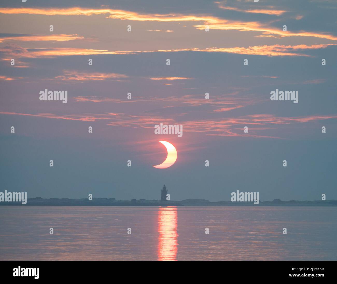 Une éclipse solaire partielle est vue lorsque le soleil se lève derrière le phare de Delaware Breakwater, le jeudi 10 juin 2021, à Lewes Beach, dans le Delaware. L'éclipse solaire annulaire ou « anneau de feu » n'est visible que dans certaines parties du Groenland, du nord de la Russie et du Canada. Crédit photo : (NASA/Aubrey Gemignani) Banque D'Images
