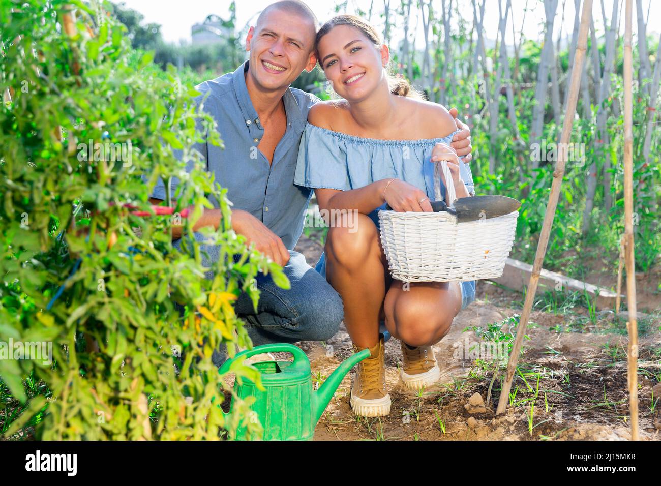 Portrait d'un couple avec une boîte d'eau et un panier sur le champ de la ferme Banque D'Images