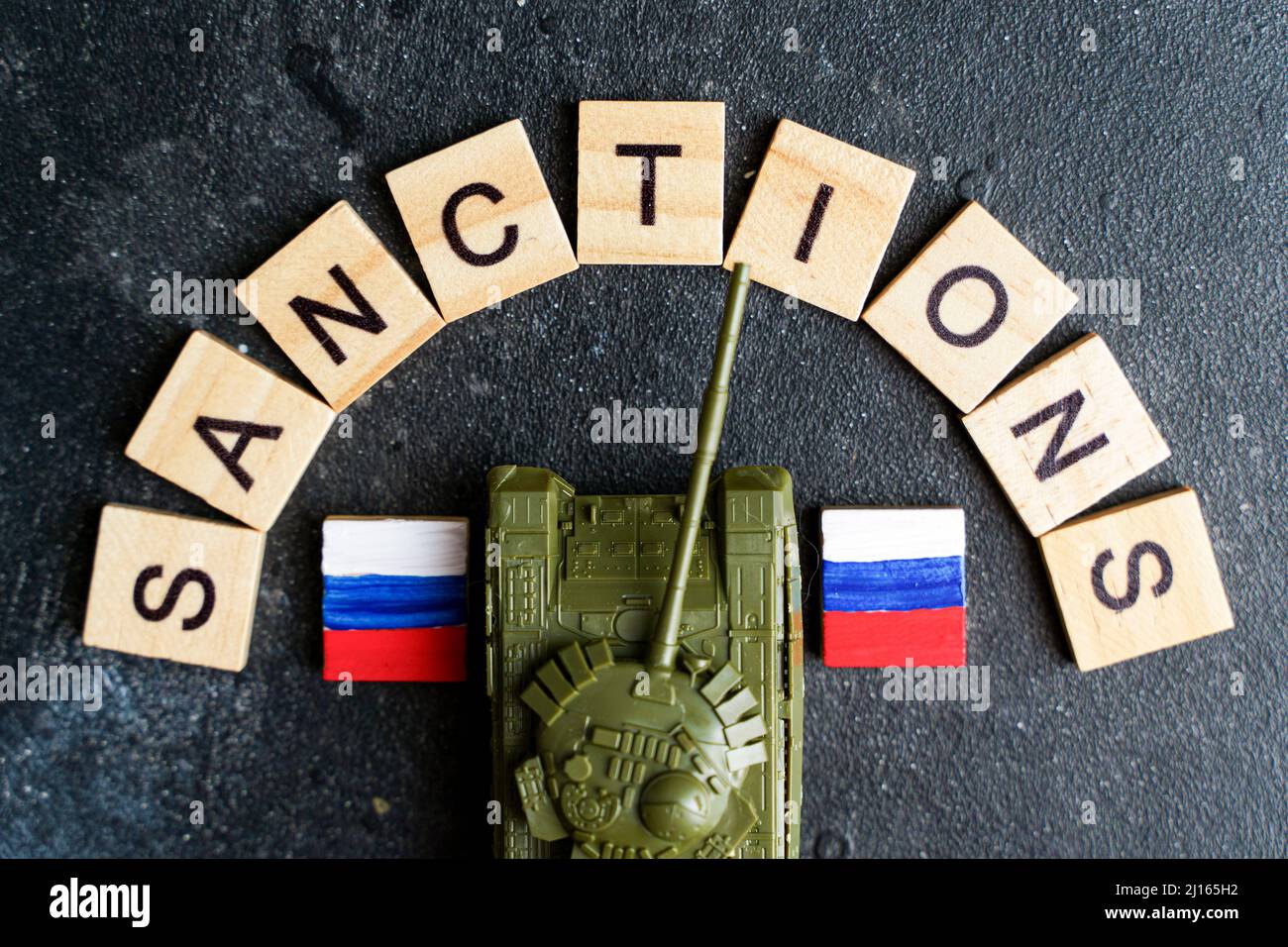 Concept de sanctions contre la Russie. Réservoir à jouets et inscription sanctions sur fond sombre. Conflit de guerre en Ukraine, défaut de paiement, crise économique et monétaire en Russie. Photo de haute qualité Banque D'Images