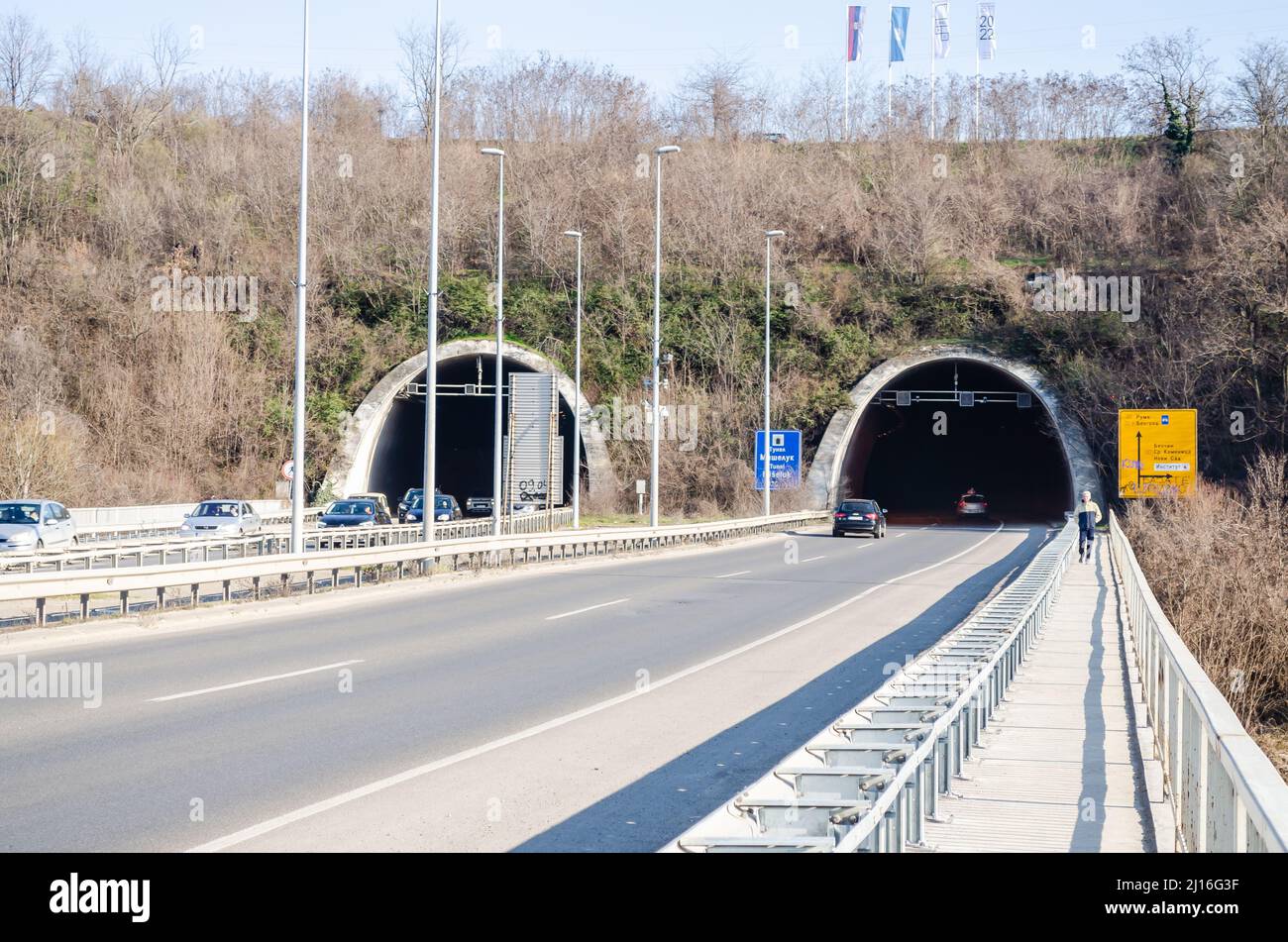 Novi Sad, Serbie. Mars - 16. 2021. Tunnel au bout du pont Liberty avec des voitures et des panneaux de signalisation sous la partie de la montagne Fruska gora. Éditorial Banque D'Images