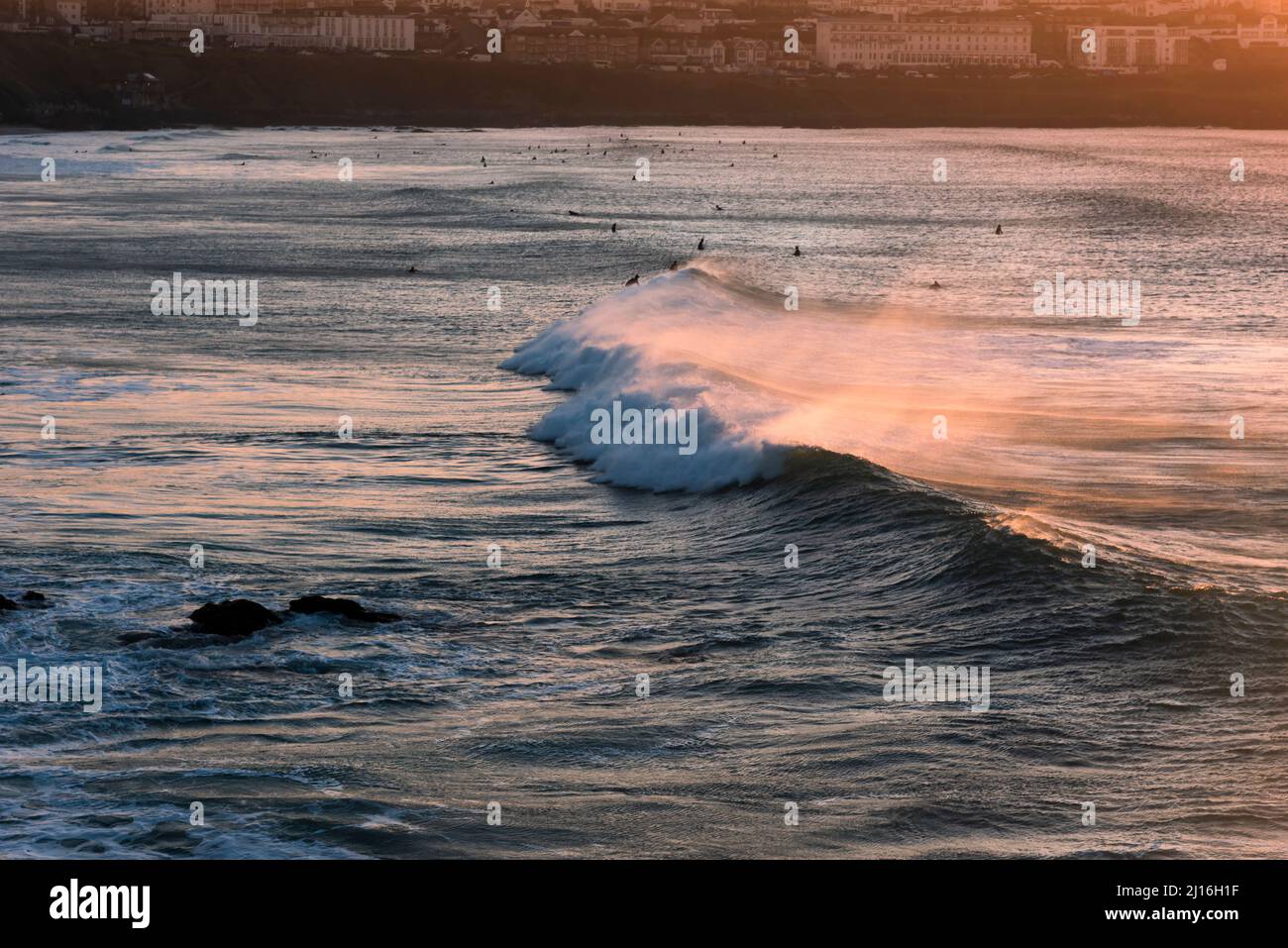 Lumière dorée intense d'un spectaculaire coucher de soleil sur la baie de Fistral à Newquay, en Cornouailles. Banque D'Images